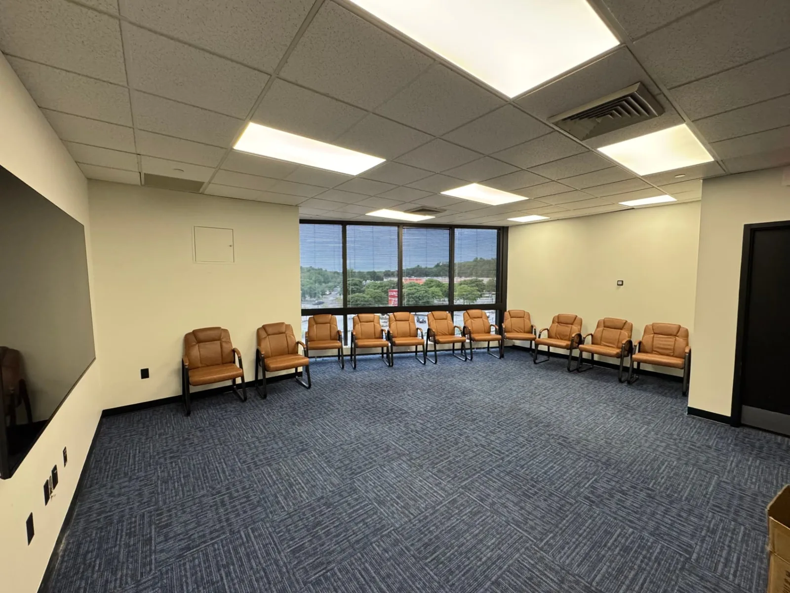 Second group room at Shine Wellness & Recovery with chairs arranged along windows overlooking Broadway in Saugus